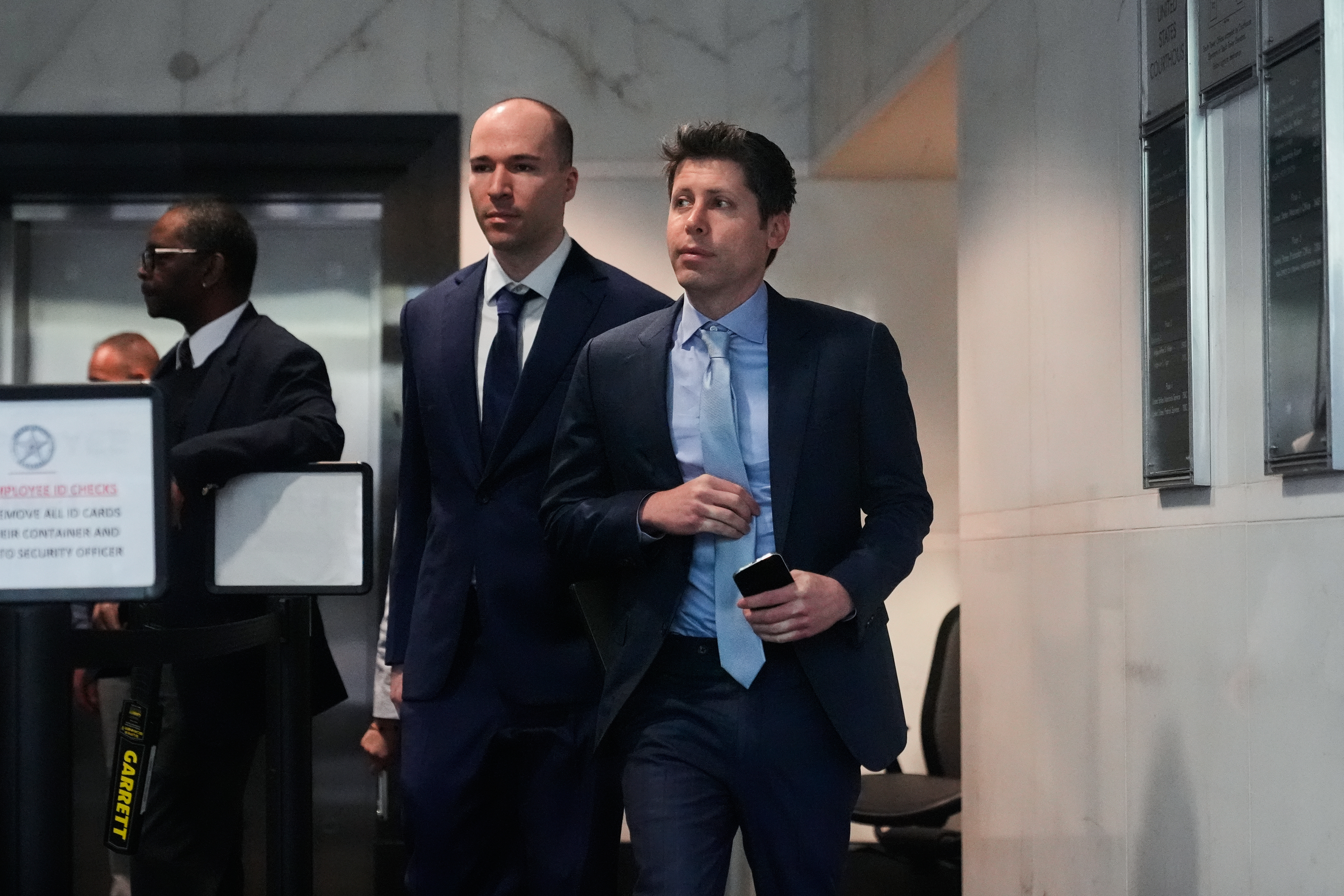 Sam Altman, right, and OpenAI president Greg Brockman, center, arrive at the U.S. District Court in Oakland, Calif., Thursday, April 30, 2026.