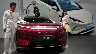 Models stand next to a latest EV car from Chinese automaker BYD showcased at the Auto China 2026, in Beijing, Saturday, April 25, 2026.