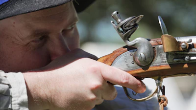 A.J. Drake, a historic interpreter, aims his Brown Bess flintlock replica musket during a Revolutionary War event in Halifax, N.C., on April 10, 2026.