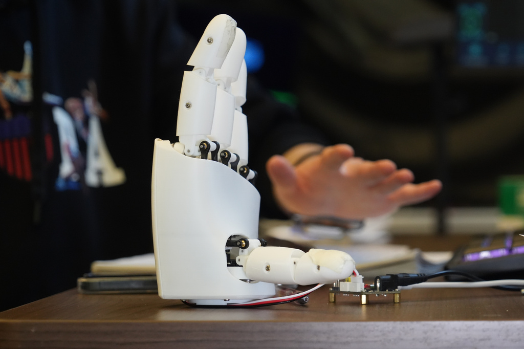 Massachusetts Institute of Technology mechanical engineering graduate student Dian Li demonstrates how an ultrasound wristband can help a robotic hand mimic full hand motions in Cambridge, Mass, on Tuesday, April 14, 2026.