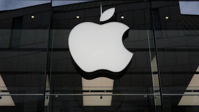 The Apple logo is illuminated at a store in Munich, April 2, 2026.