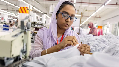 Ruma Aktar, a sewing machine operator, wears her prescription eyeglasses while working at a garment factory in Gazipur, on the outskirts of Dhaka, Bangladesh, June 30, 2026.