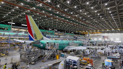 Boeing employees work on a 737 MAX airplane on the final assembly line at Boeing's plant in Renton, Wash., on June 15, 2022.