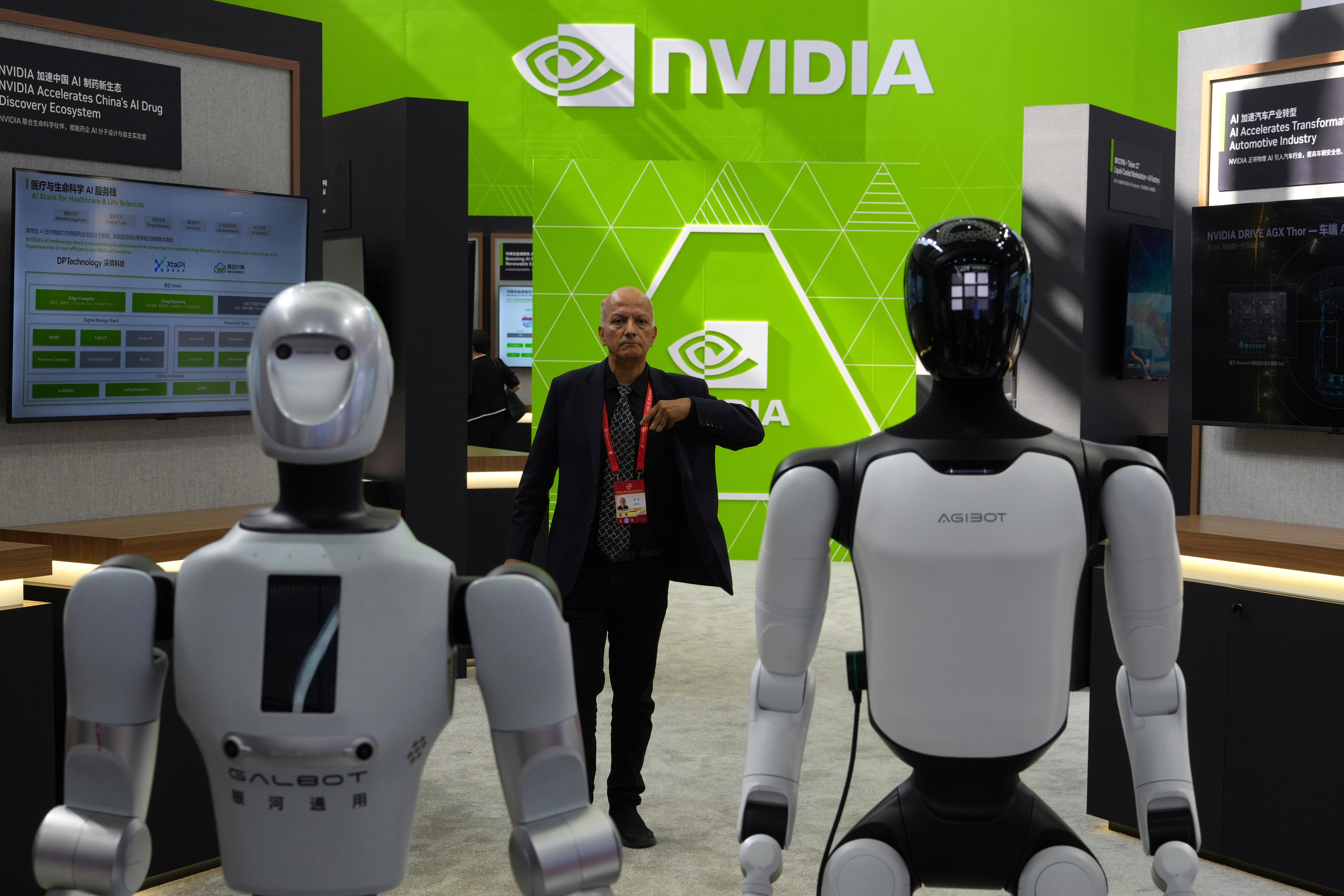 A worker stands near robots at the Nvidia booth during the China International Supply Chain Expo in Beijing on June 22, 2026.