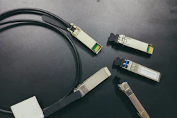 Collection of SFP transceivers and network cables on dark background