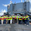 Rob Madden, Mitsubishi Motors North America, Inc., (center, with scissors) cuts the ceremonial ribbon to celebrate Port Freeport as a new U.S. distribution port for the company’s vehicles, as new Mitsubishi vehicles roll off the Höegh Sunrise.