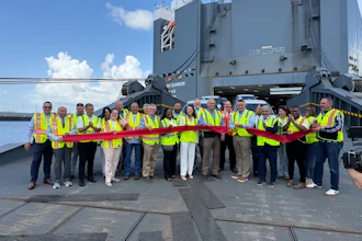 Rob Madden, Mitsubishi Motors North America, Inc., (center, with scissors) cuts the ceremonial ribbon to celebrate Port Freeport as a new U.S. distribution port for the company’s vehicles, as new Mitsubishi vehicles roll off the Höegh Sunrise.