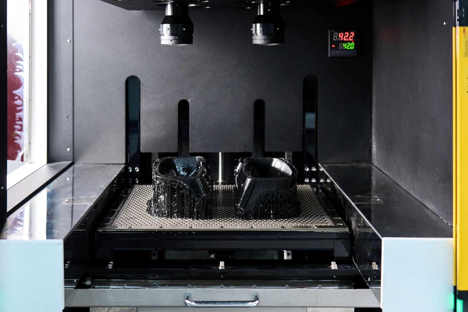 A vat photopolymerization process fabricates a component by curing liquid resin layer by layer using light.