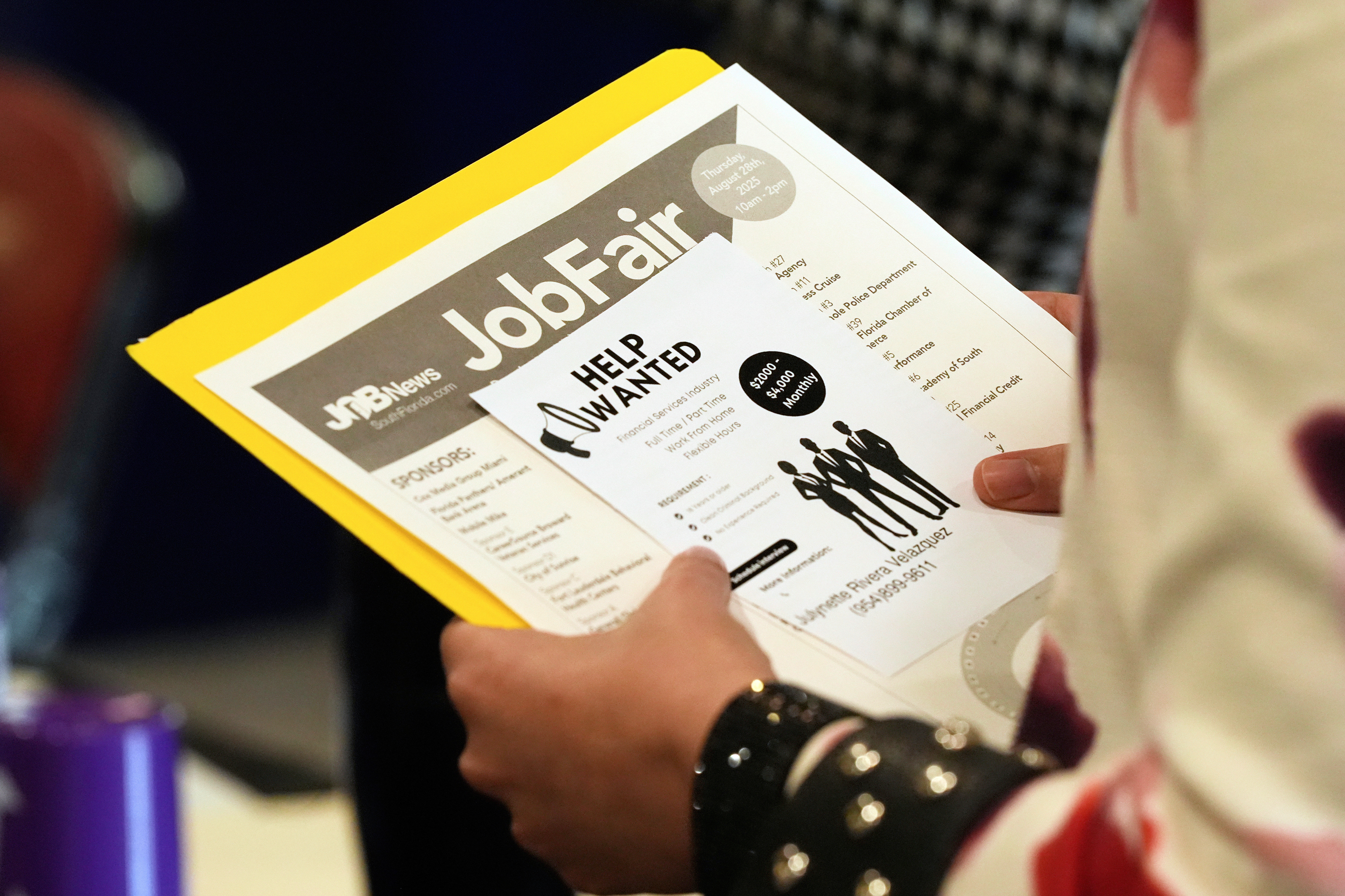 A job seeker waits to talk to a recruiter at a job fair in Sunrise, Fla., Aug. 28, 2025.