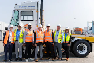 Orange EV and APM Terminals team members gather alongside an Orange EV electric terminal truck.