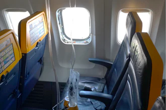 This undated photo provided by the National Transportation Safety Board on Thursday, Aug. 13, 2026, shows the shattered window on a Ryanair plane that was broken by a stray engine part shortly after takeoff, causing a man's head to be sucked into the hole.