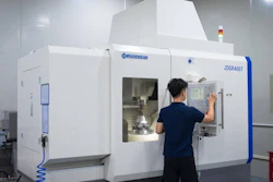 Technician operating JDGR400T CNC machining center in industrial facility