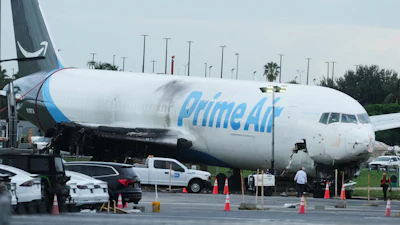 Workers inspect an Amazon cargo plane that overshot a runway four days ago at Miami International Airport, Thursday, Sept. 10, 2026, in Miami.
