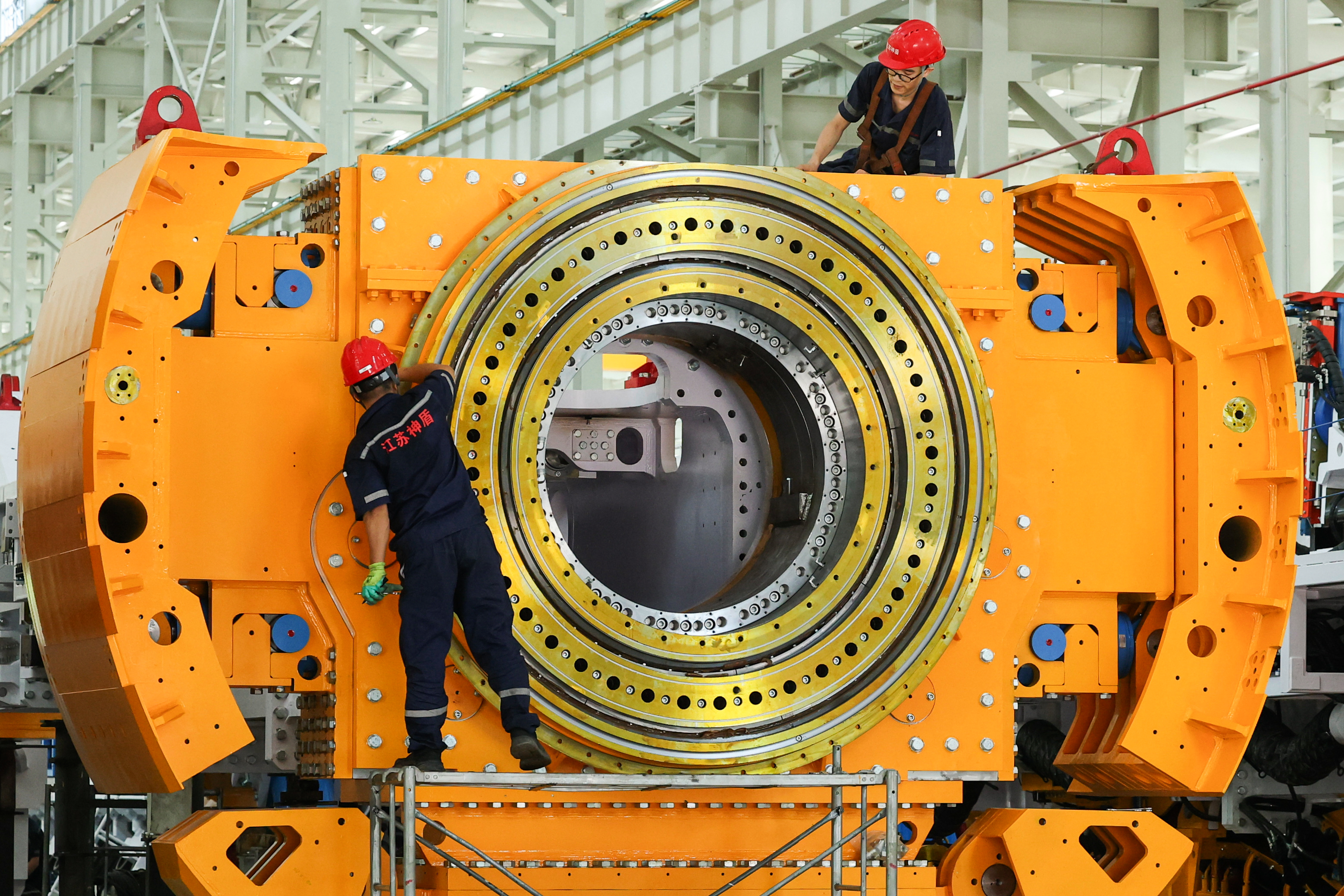 Workers install a tunnel‑boring machine at a factory in Jinhu county in eastern China's Jiangsu province on Aug. 25, 2026.