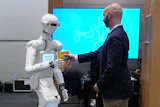 A man receives a box of chocolate powder drink from a robot during a demonstration of AI-based robotics in Europe at the European Parliament in Brussels, Wednesday, Sept. 2, 2026.