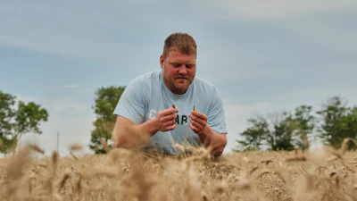 Bryce Black inspects strands of wheat at his farm in Beloit, Kan., July 29, 2026.