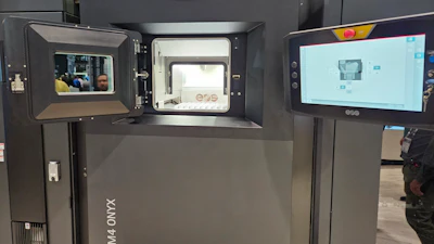 3D printer with open chamber displaying printing platform and control interface