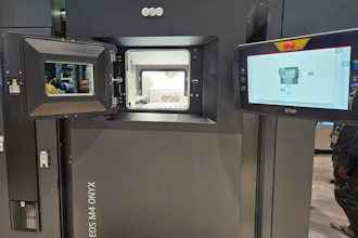 3D printer with open chamber displaying printing platform and control interface