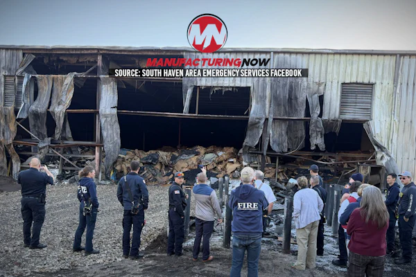 Emergency responders and firefighters assess damage at industrial warehouse with collapsed roof and debris