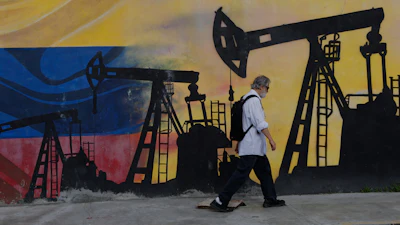 A pedestrian walks past a mural featuring oil wells in Caracas, Venezuela, Saturday, Aug 29, 2026, a day after President Donald Trump announced a deal giving the United States a stake in Venezuela’s oil reserves.