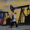 A pedestrian walks past a mural featuring oil wells in Caracas, Venezuela, Saturday, Aug 29, 2026, a day after President Donald Trump announced a deal giving the United States a stake in Venezuela’s oil reserves.