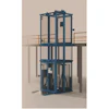 Blue industrial vertical lift platform with safety cage and railings on concrete structure