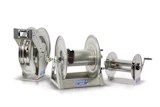 Three stainless steel industrial hose reels of different sizes with manual crank handles