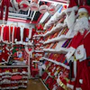 A vendor waits for customers near Santa costumes for sale at the Yiwu International Trade Market in Yiwu, eastern China's Zhejiang province on April 10, 2025.