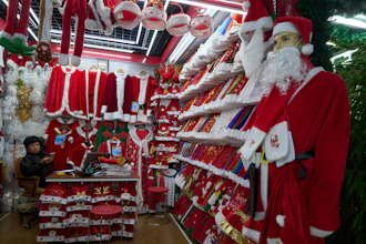 A vendor waits for customers near Santa costumes for sale at the Yiwu International Trade Market in Yiwu, eastern China's Zhejiang province on April 10, 2025.