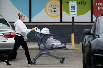 A woman pushes a shopping cart as she leaves a grocery store in Arlington Heights, Ill., Sept. 30, 2026.