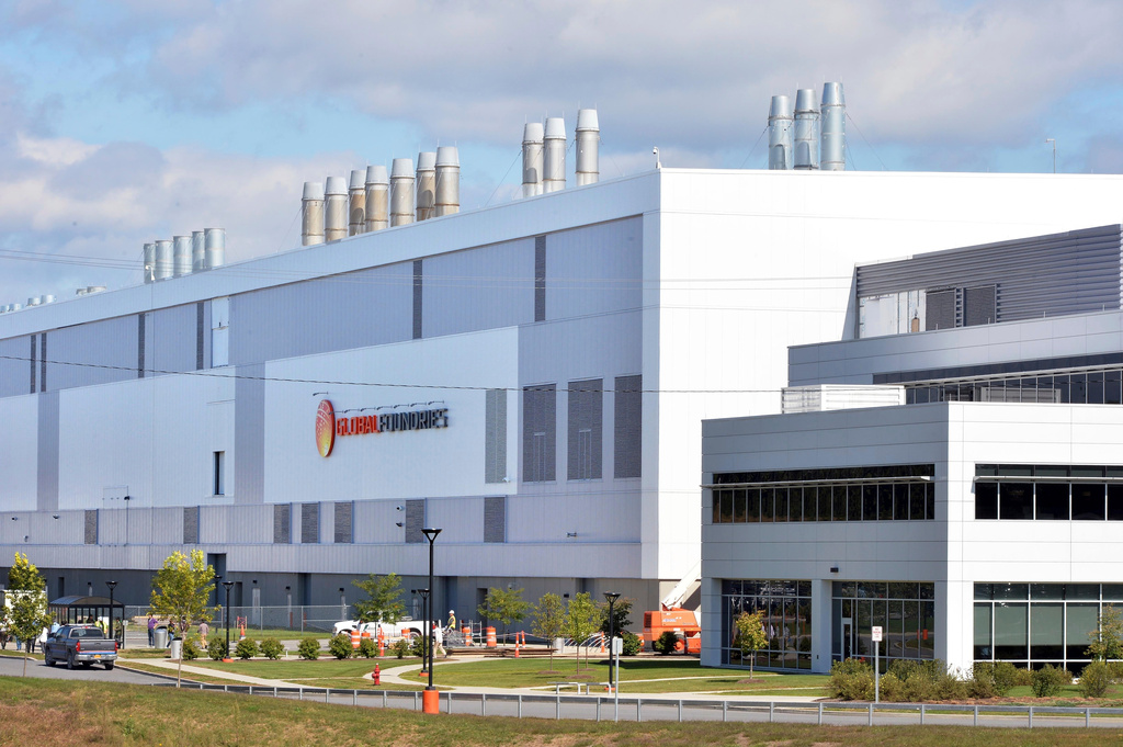 Modern industrial facility with Helios Technologies signage, featuring blue and white architecture with cylindrical ventilation stacks on the roofline.