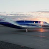 Virgin Galactic SpaceShipTwo aircraft on runway at sunset with illuminated cabin windows