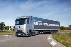 Mercedes-Benz fuel cell electric hydrogen-powered truck driving on highway with green landscape