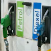 Green and blue fuel pump nozzles labeled Petrol and Diesel at a gas station dispenser