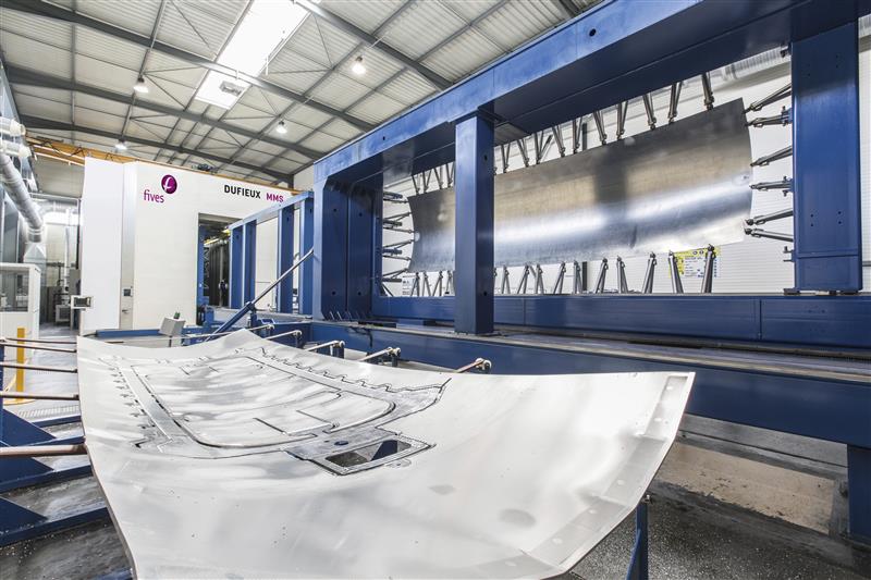 Industrial CNC sheet metal processing machine with blue frame in modern manufacturing facility
