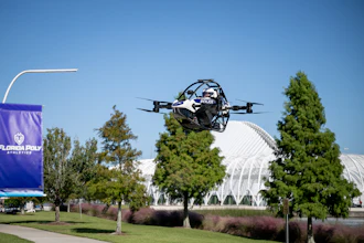 Police drone in flight over Florida Poly campus with trees and modern architecture in background