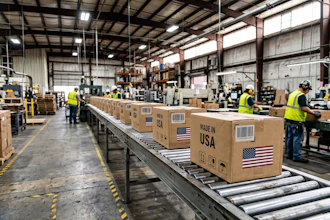 Workers in safety vests process cardboard boxes marked 'Made in USA' on a warehouse conveyor belt system.