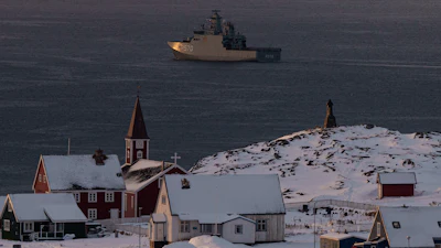 Arctic coastal settlement with red church, snow-covered buildings, and icebreaker ship in Greenlandic waters