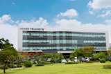 Hyundai Transys modern corporate headquarters building with glass facade and landscaped grounds under blue sky