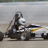 Black and white formula SAE race car with number 35 on concrete track near barrier
