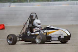 Black and white formula SAE race car with number 35 on concrete track near barrier