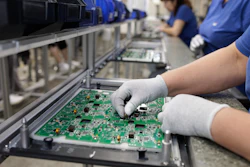 Electronics factory workers assembling and inspecting green circuit boards on an industrial production line