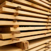 Stacked wooden planks with natural grain texture stored in a warehouse or lumber yard