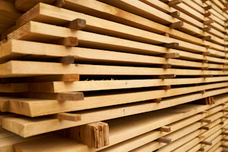Stacked wooden planks with natural grain texture stored in a warehouse or lumber yard