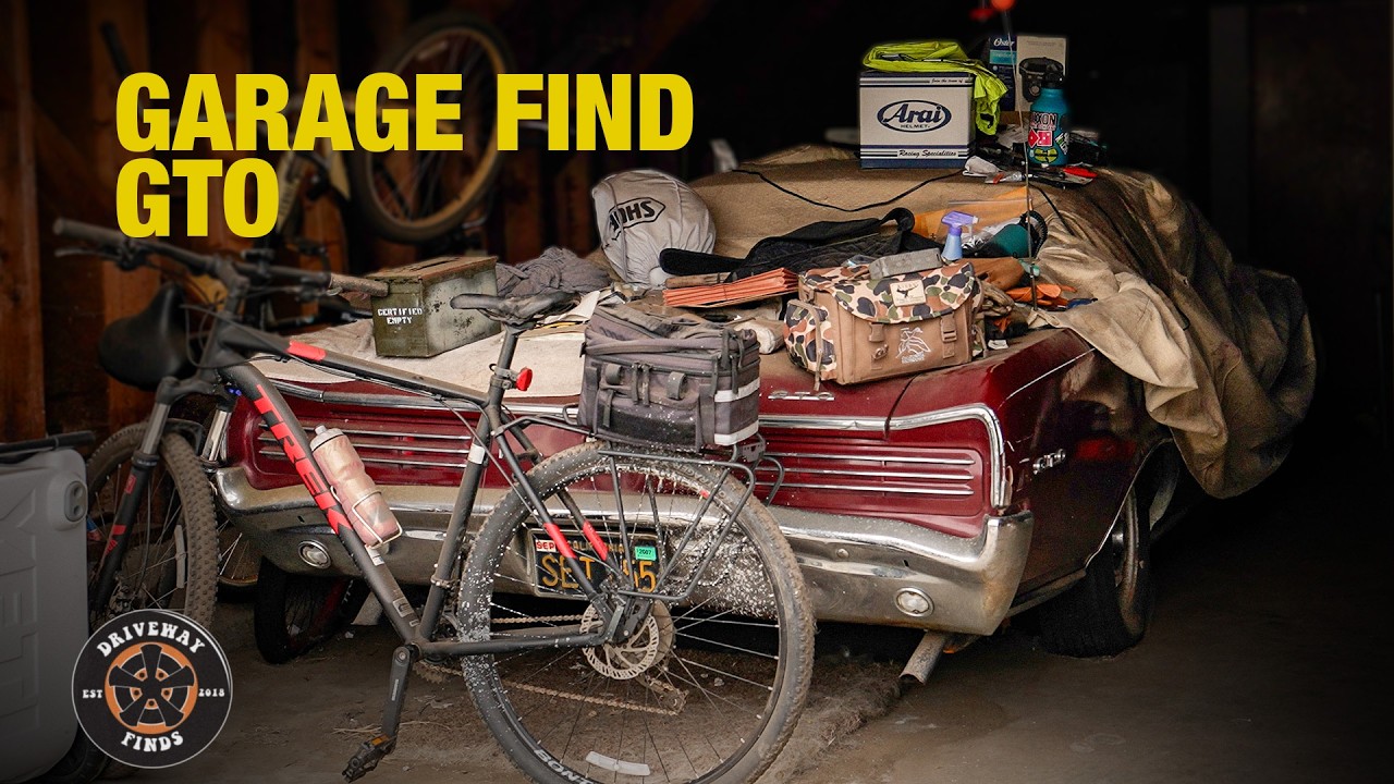 Garage find collection featuring red bicycle, car door panel, tools, and Arai helmet box on workbench