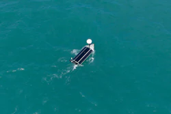 Aerial view of a pontoon boat on clear turquoise water with white canopy