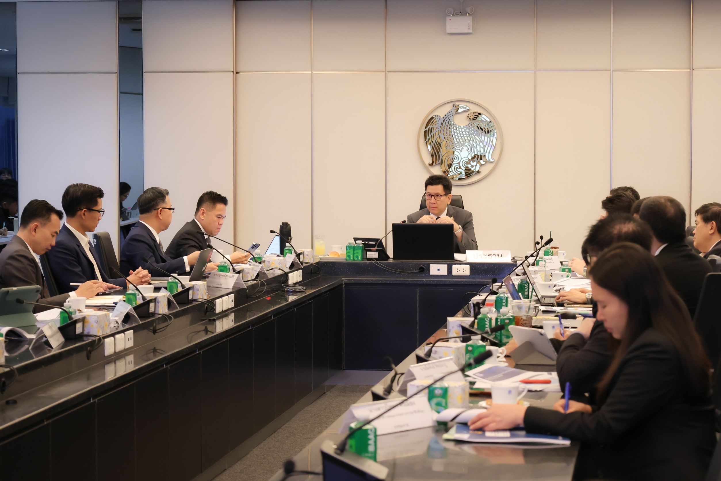 Formal business meeting with professionals seated at conference table in modern office setting