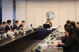 Formal business meeting with professionals seated at conference table in modern office setting