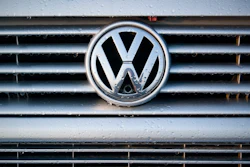 Volkswagen logo on wet vehicle grille with chrome trim